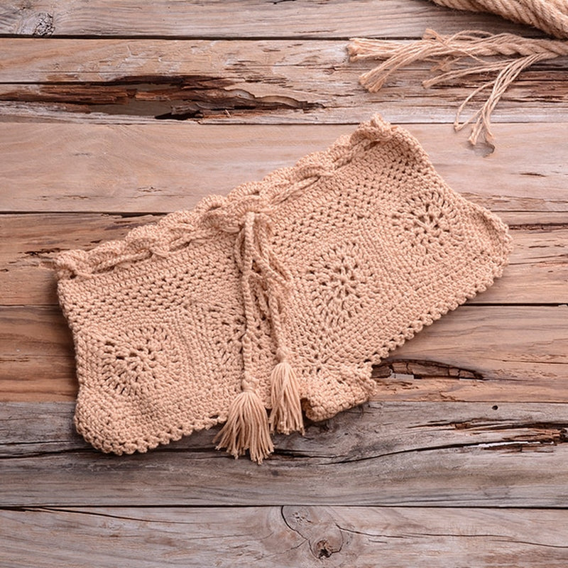 Crochet bikini set in neutral hue against rustic wooden backdrop, showcasing delicate handmade craftsmanship and summer-ready style.