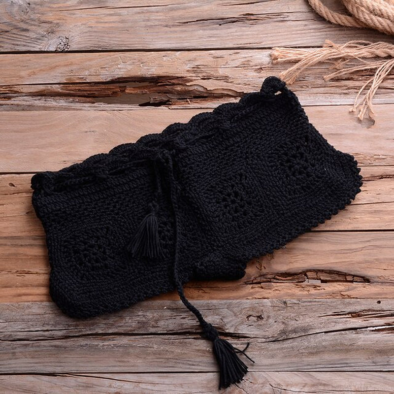 Crochet black bikini set on rustic wooden surface with rope accents